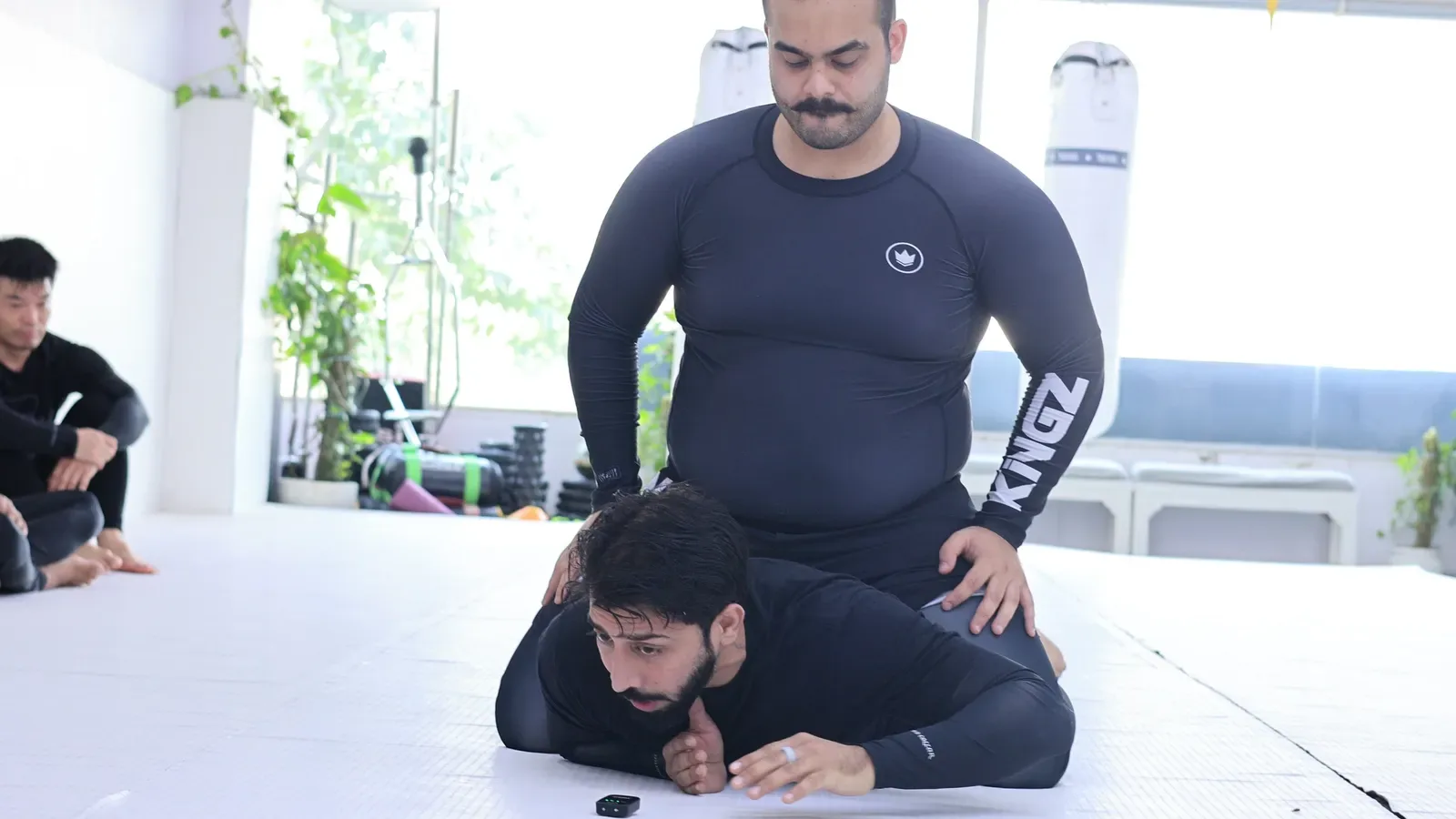 Back mount escape posture in No-Gi BJJ: one arm posted like a pillow under the head, at Knots & Collar, New Delhi, India