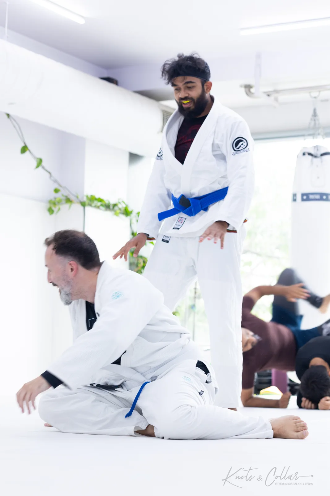 Two training partners share a laugh during Brazilian Jiu-Jitsu drilling at Knots & Collar in Defence Colony, New Delhi