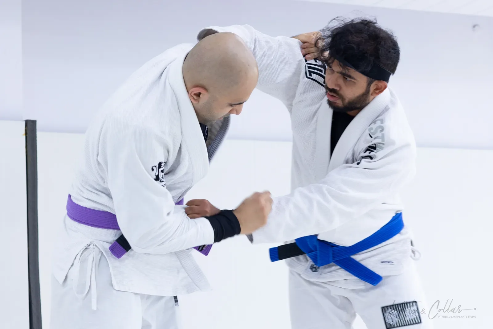 Two students grip fighting from standing in the gi during Brazilian jiu-jitsu training at Knots & Collar, Defence Colony, New Delhi