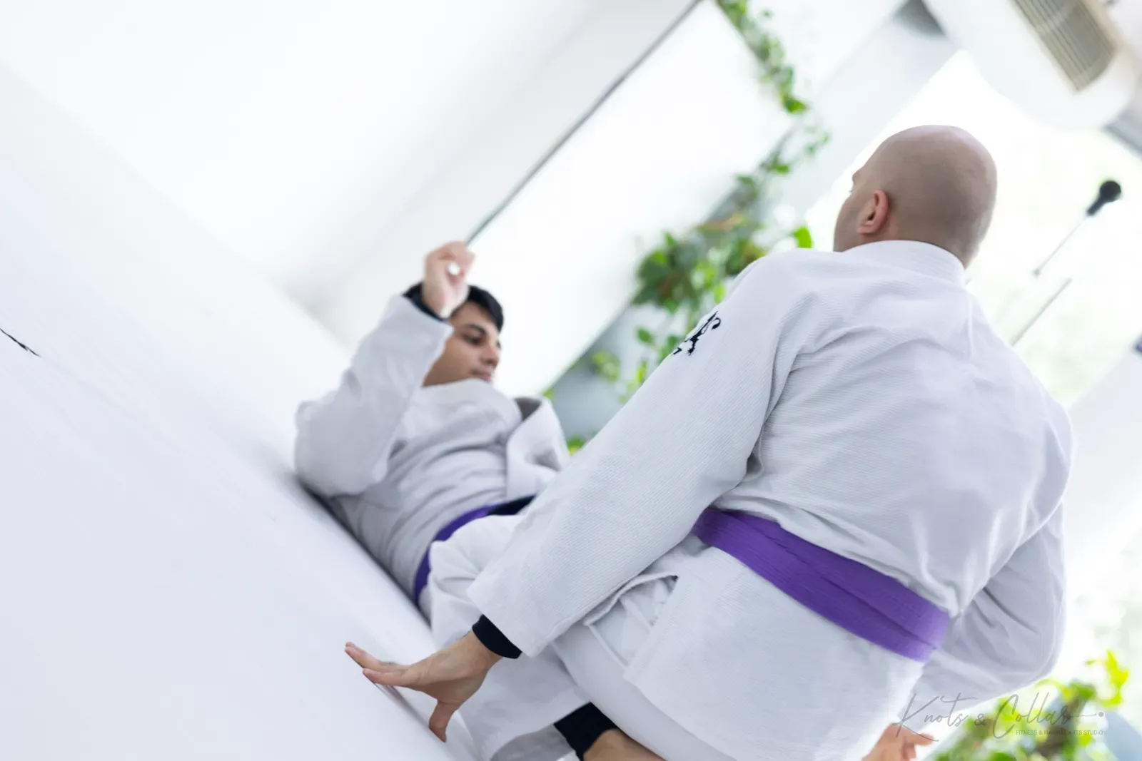 A student playing guard from the bottom during Brazilian jiu-jitsu training at Knots & Collar, Defence Colony, New Delhi