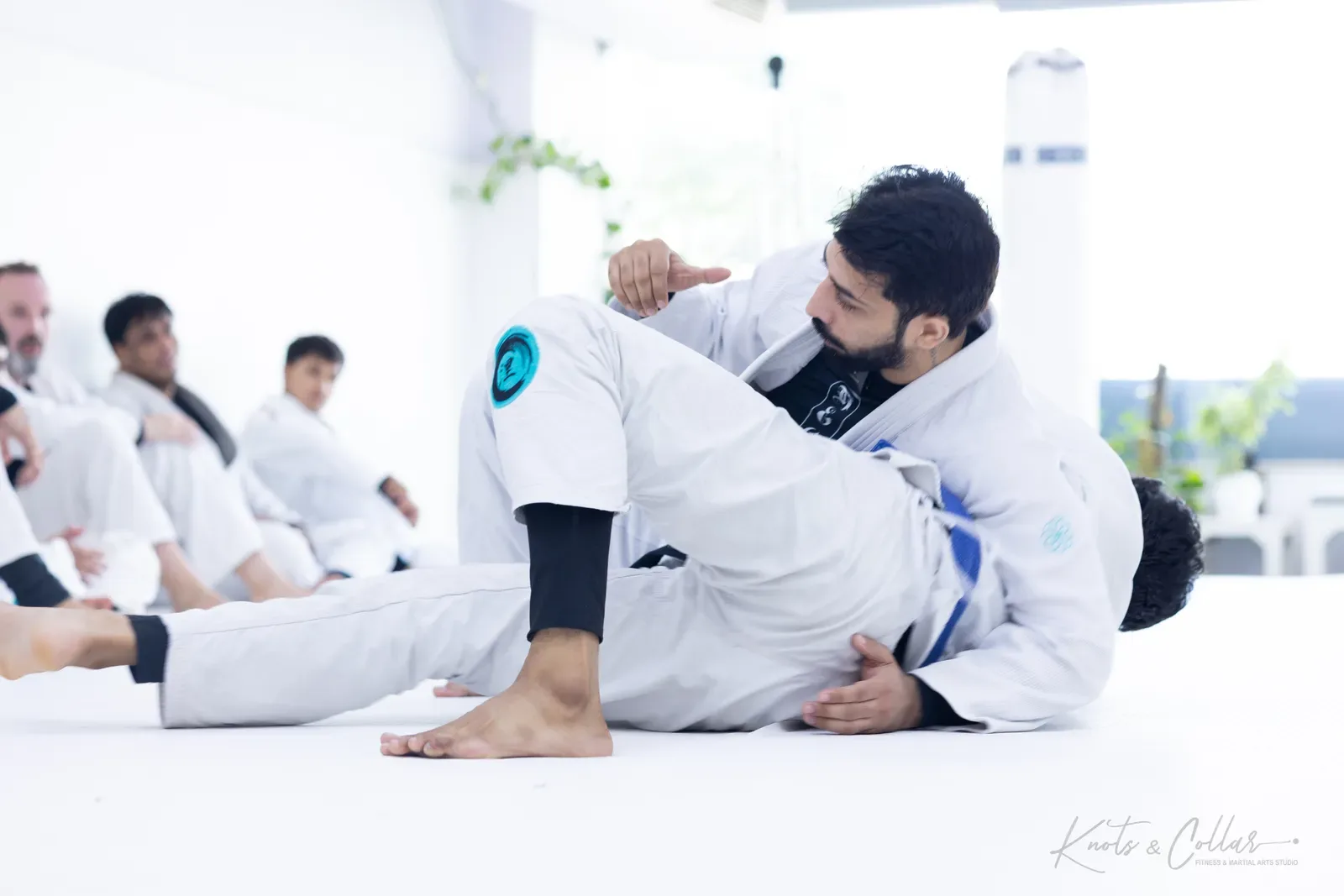 A student controlling a partner while passing guard during Brazilian jiu-jitsu training at Knots & Collar, Defence Colony, New Delhi