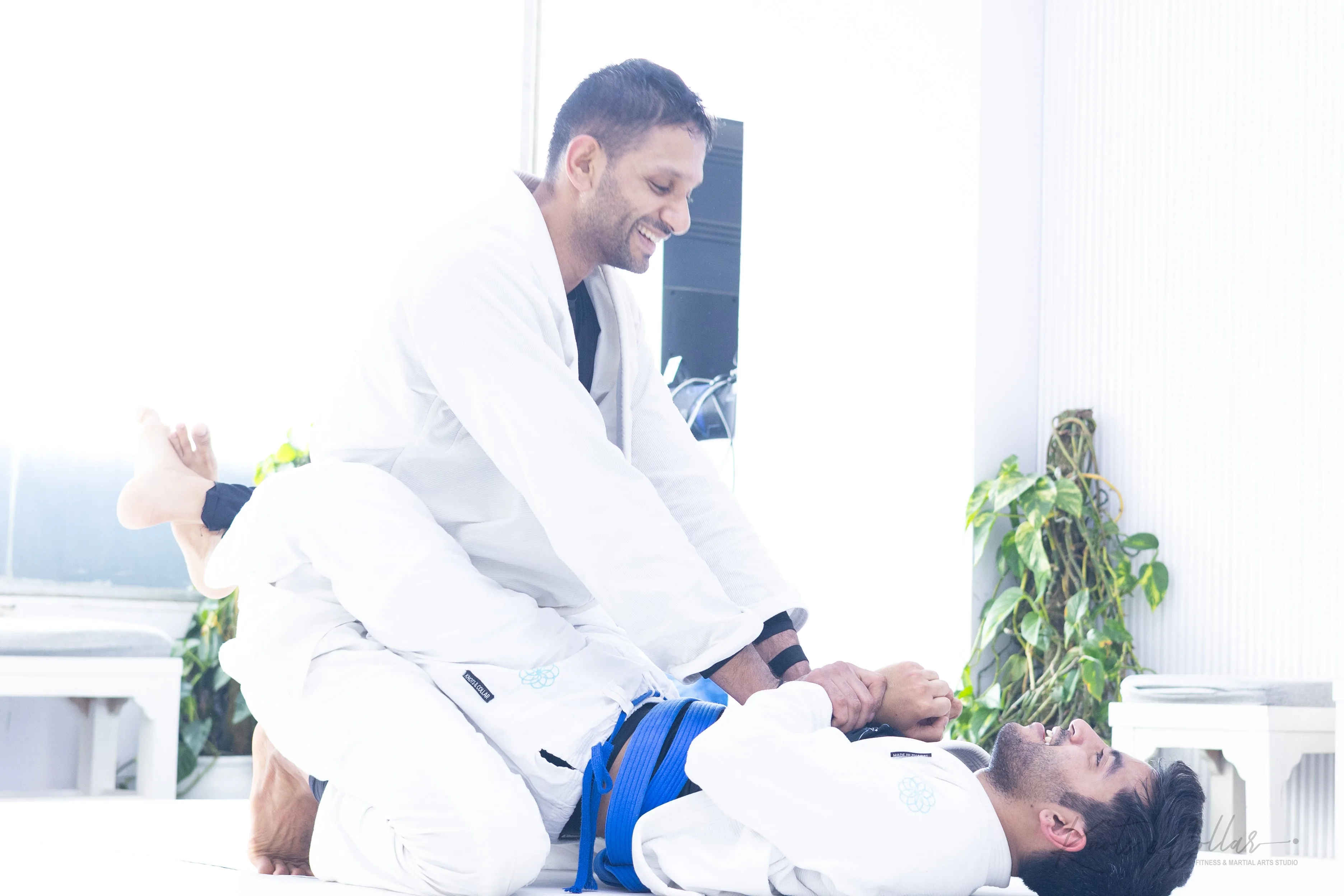 Instructor helping a student up during training — kindness in action at Knots & Collar