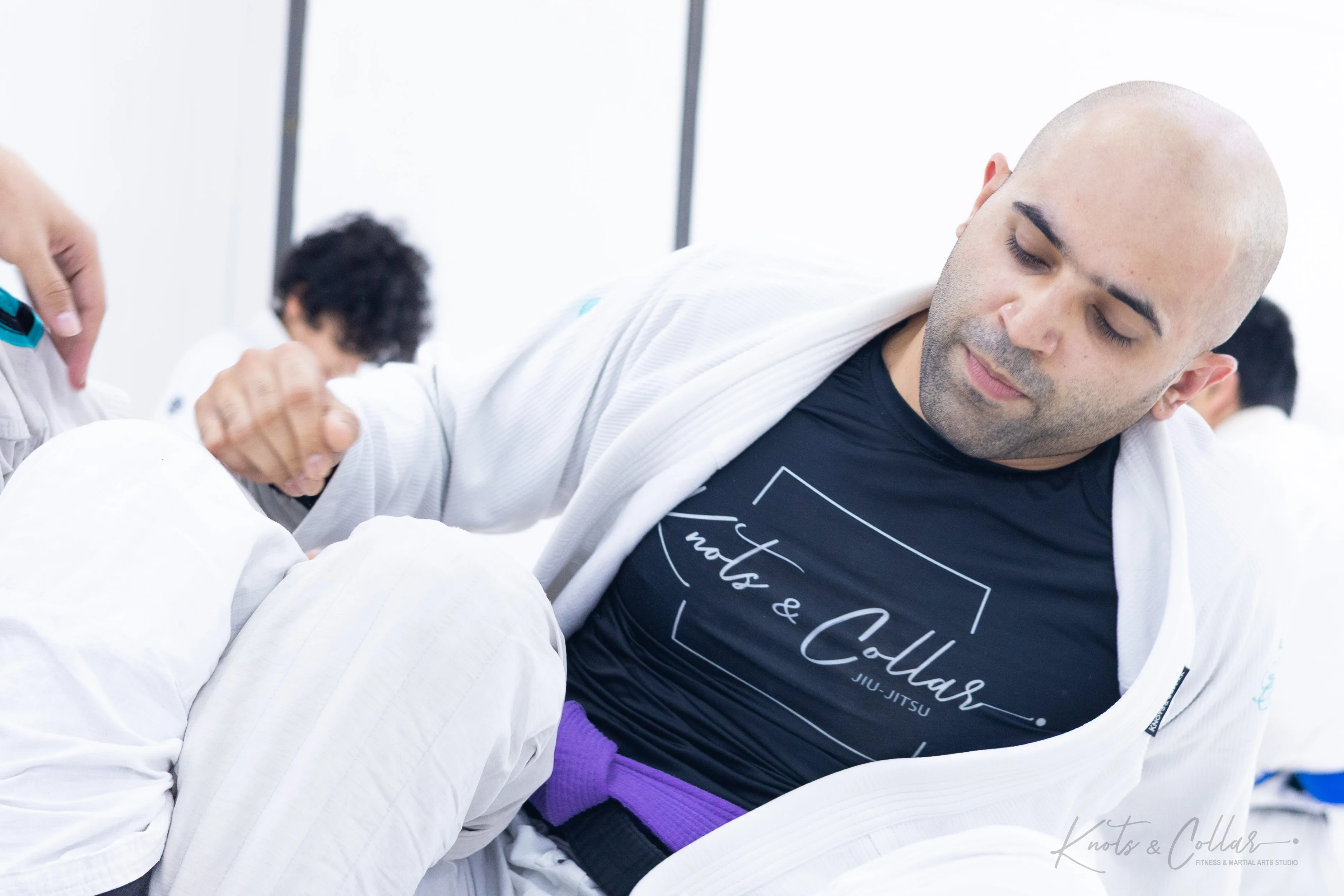 Purple belt BJJ practitioner drilling collar control technique