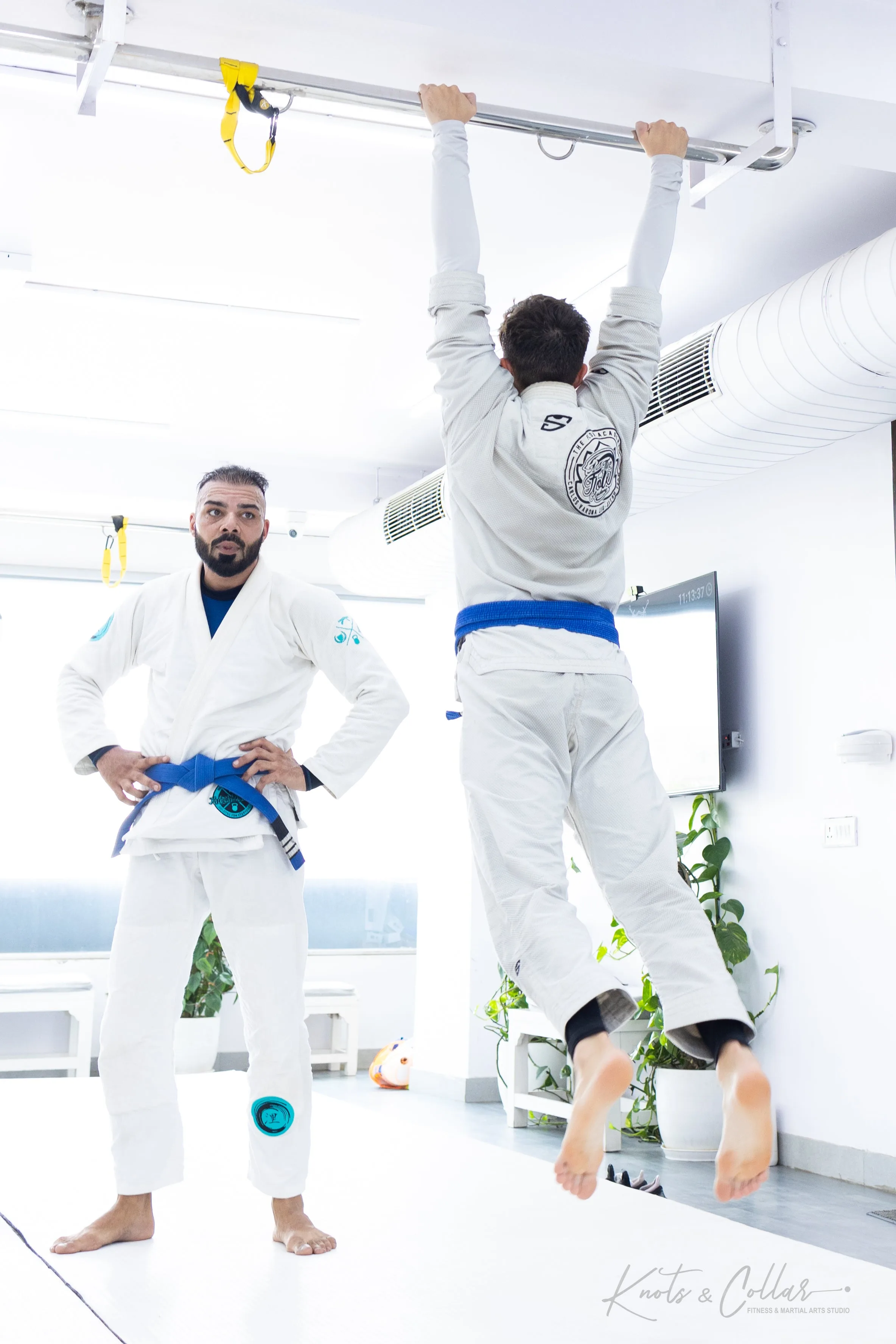 BJJ practitioner doing pull-ups as part of strength and conditioning training