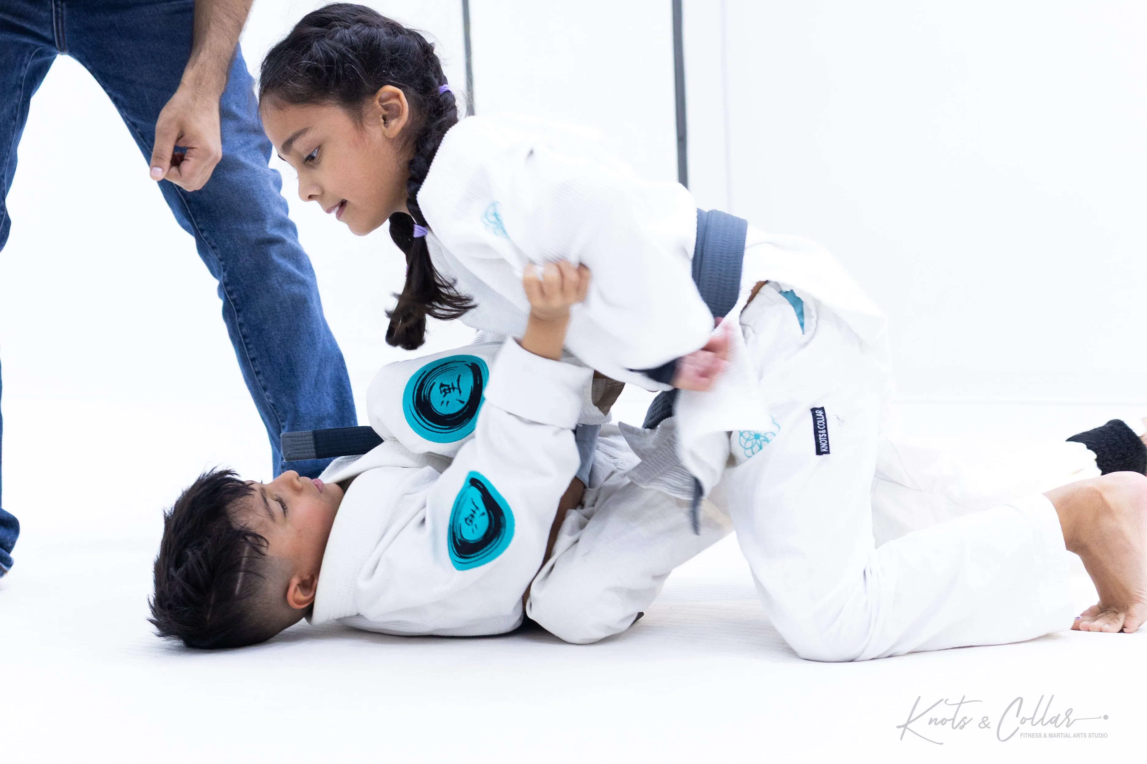 Girl practicing BJJ guard pass with instructor supervision at Knots and Collar Delhi