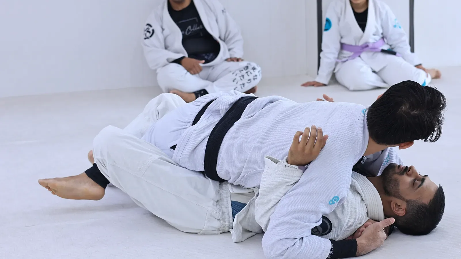 Chest-to-chest pressure from the top, shoulder driven over, while passing half guard