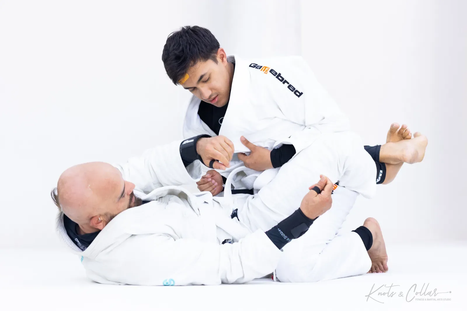 Fighting the grips from open guard during Brazilian Jiu-Jitsu rolling at Knots & Collar in Delhi
