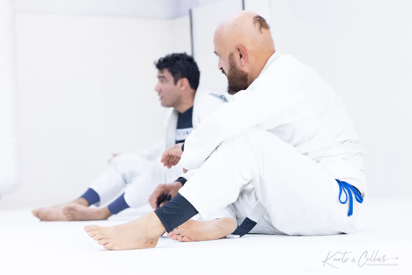 Sitting out a round against the wall at a Brazilian Jiu-Jitsu class, Knots & Collar, New Delhi, India