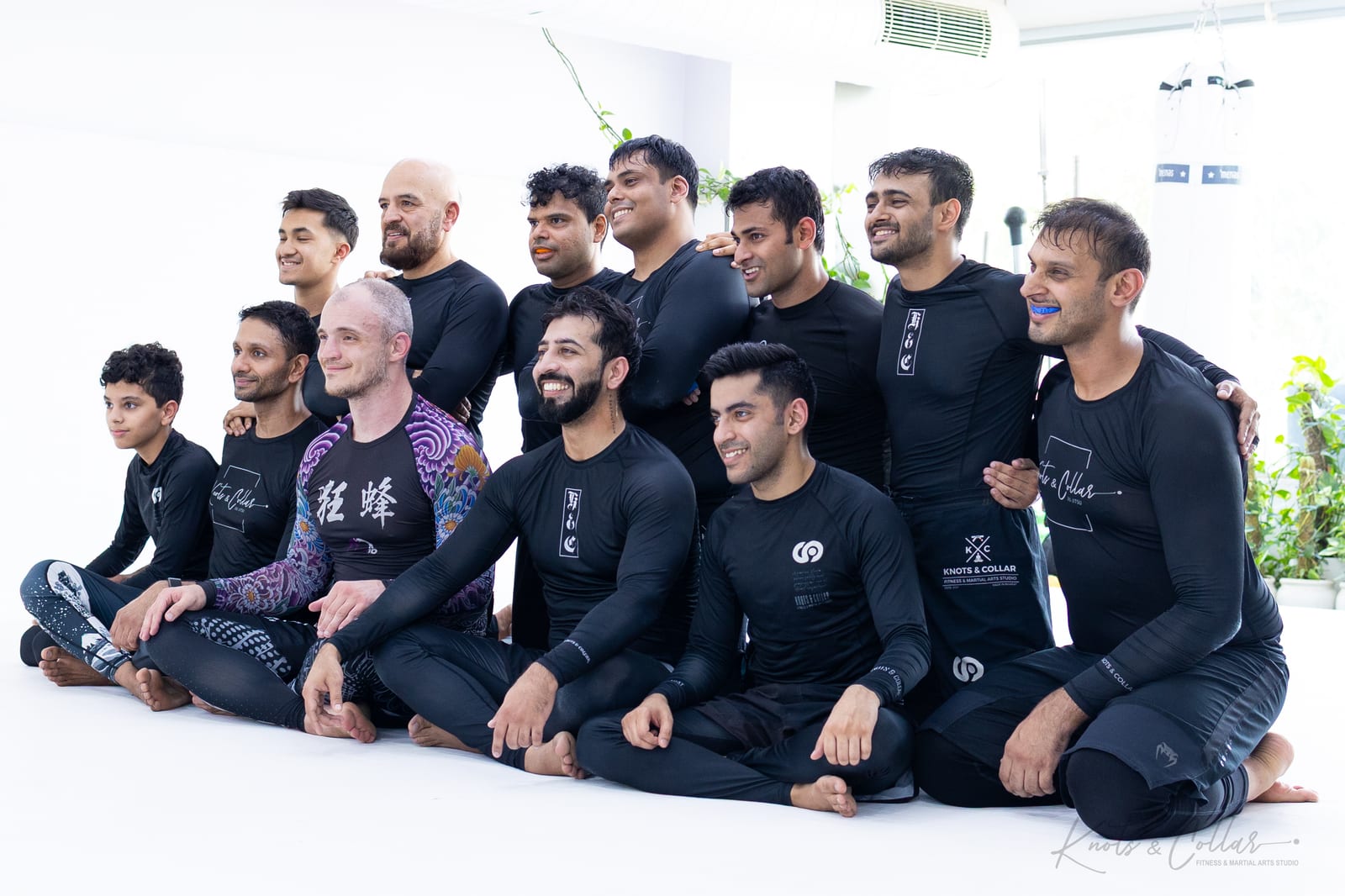 The Knots & Collar no-gi team and Professor Igor Lunyakov seated together on the white mats of the Defence Colony studio, New Delhi