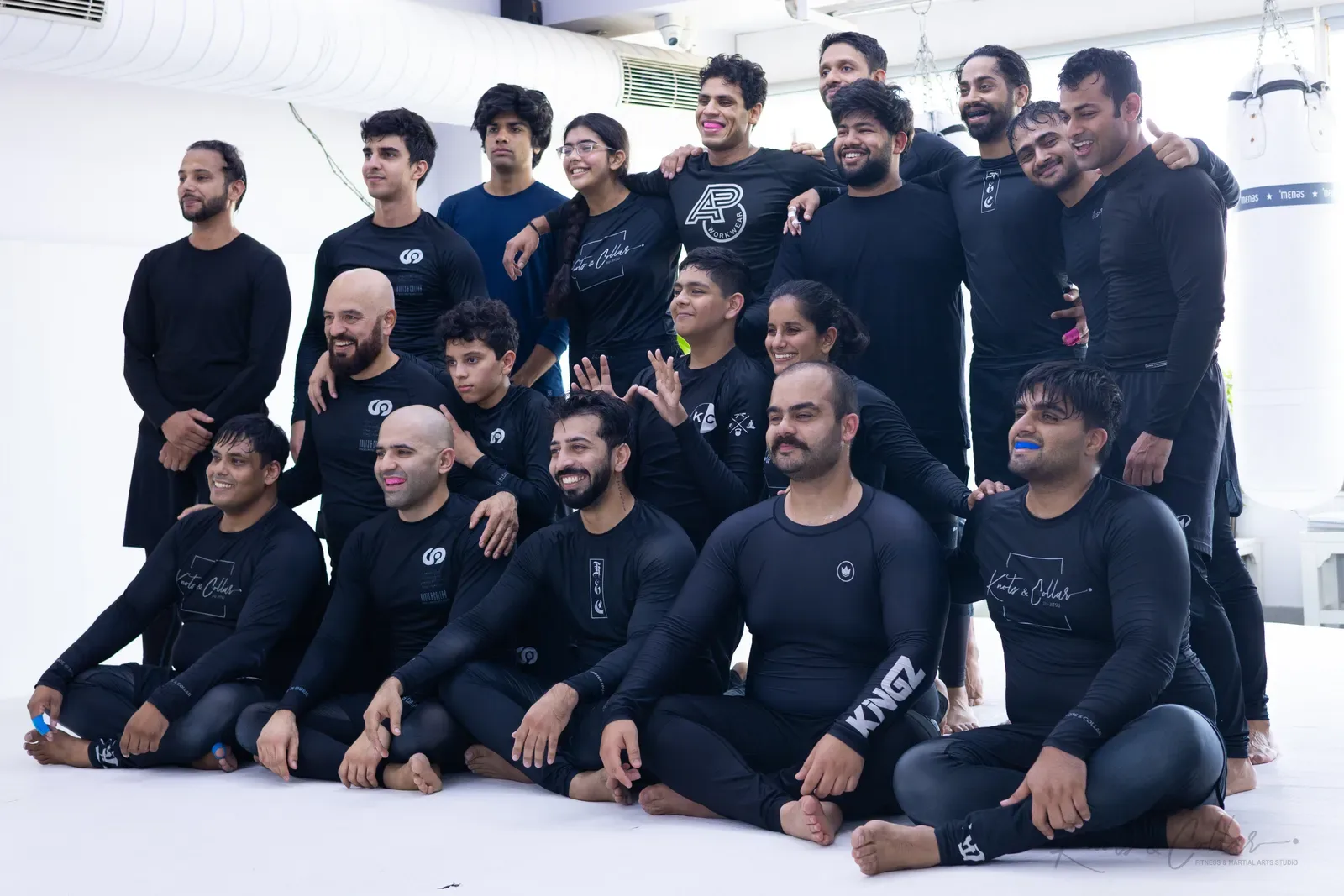 No-Gi Brazilian Jiu-Jitsu students at Knots & Collar in Delhi, laughing together on the mat after class