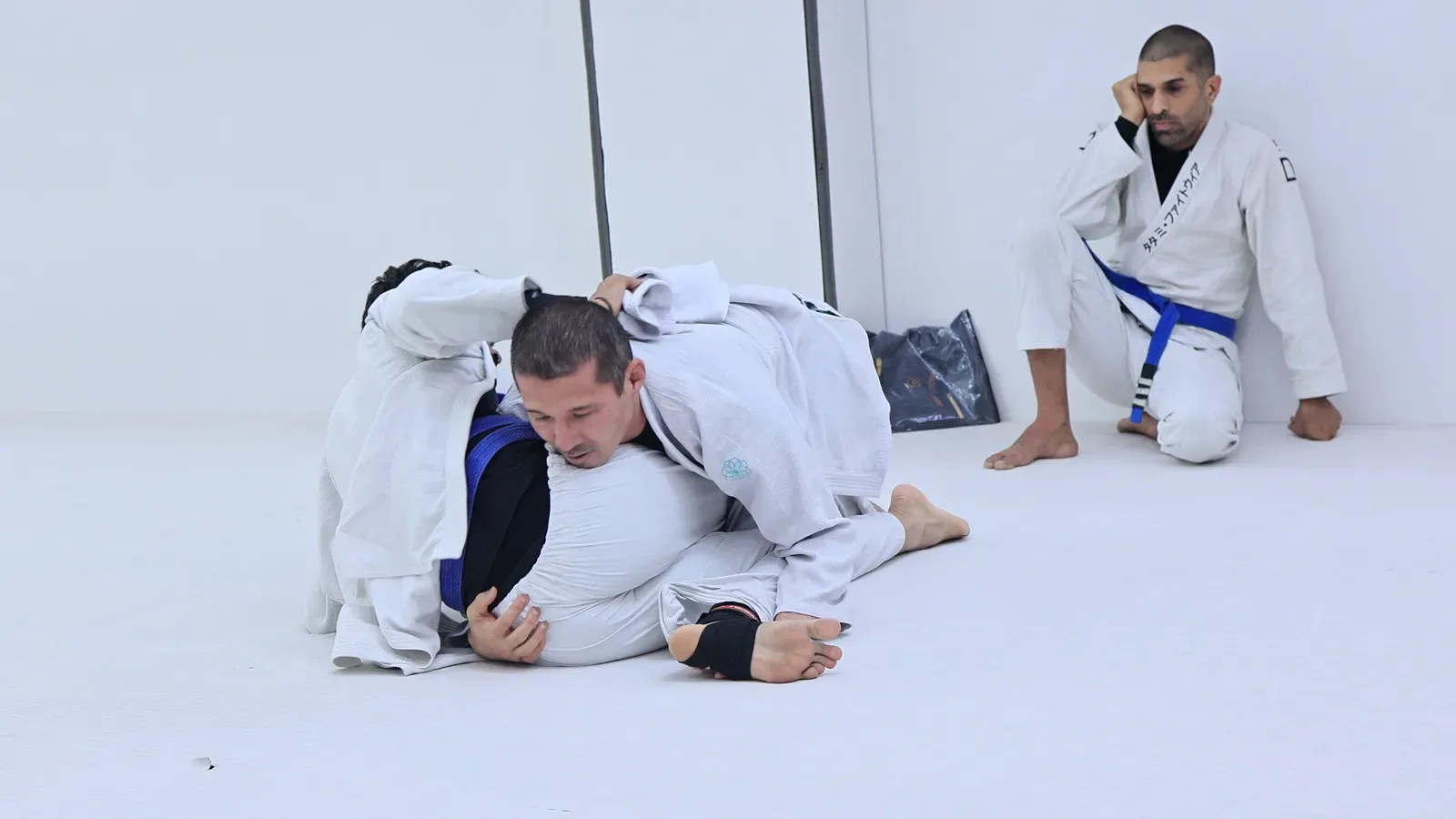 Professor Bek applying top pressure during his BJJ seminar in India as students watch