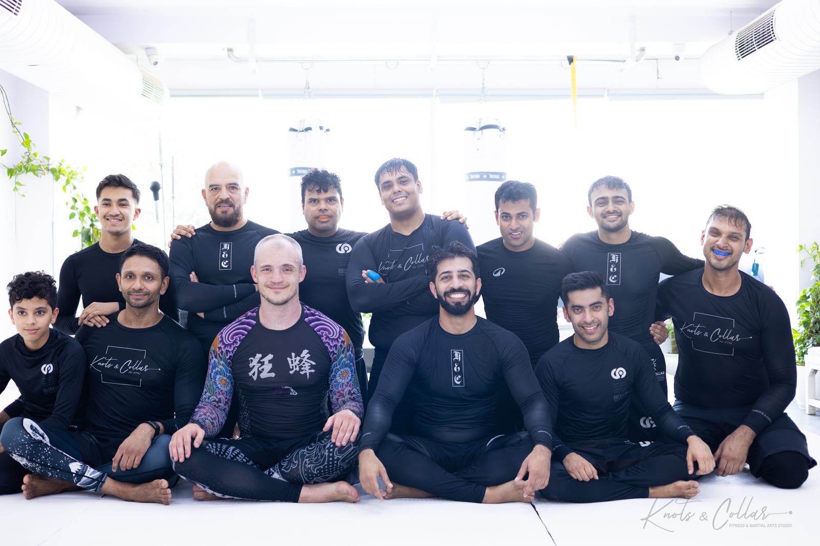 Professor Igor Lunyakov sitting with the Knots & Collar team in black rash guards after ten no-gi rounds at the Defence Colony studio in New Delhi