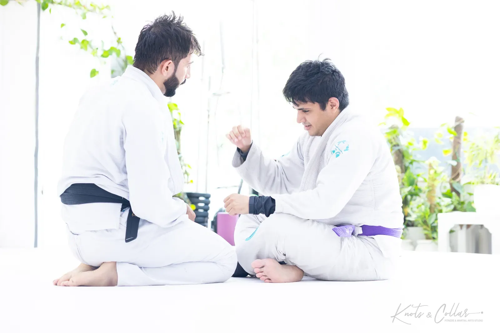 A black belt coach explaining a technique one-to-one at Knots & Collar, a Brazilian Jiu-Jitsu academy in India